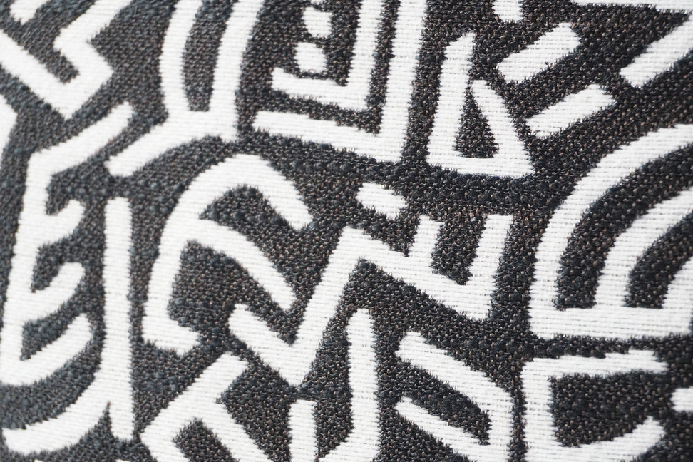 Dark gray throw pillow cover with bold white geometric maze pattern
