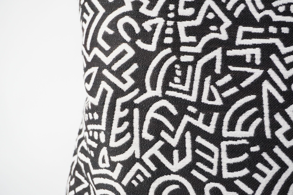 Black-and-white throw pillow cover with repeating geometric maze symbols
