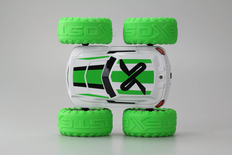Green and white stunt toy car with oversized treaded wheels, rear view