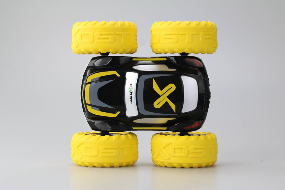 Yellow and black stunt toy car with oversized treaded wheels, front view
