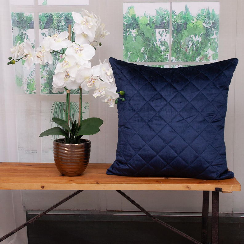 Navy quilted throw pillow front with diamond quilting on a tabletop setting.