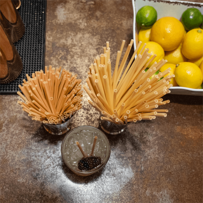 Light tan wheat stem drinking straws bundled in small holders.
