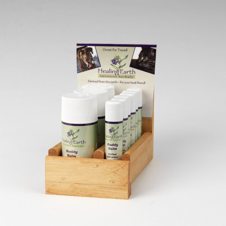Multiple balm bottles with white caps on a wooden display tray