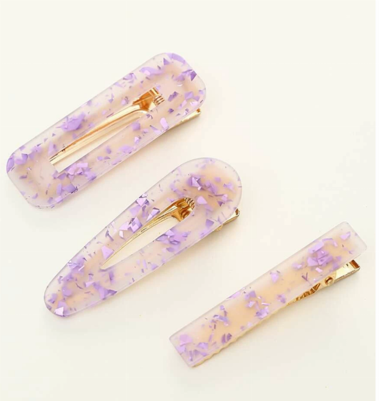 Three sparkle resin hair clips, lavender translucent with gold prongs.