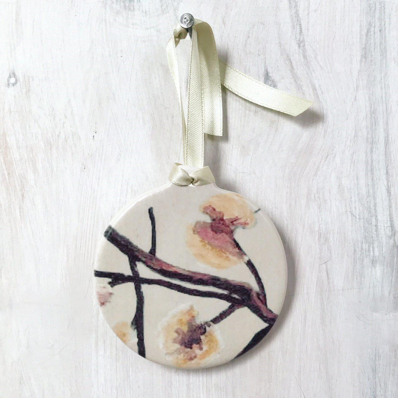 Round room ornament with cream ribbon and watercolor floral pattern.