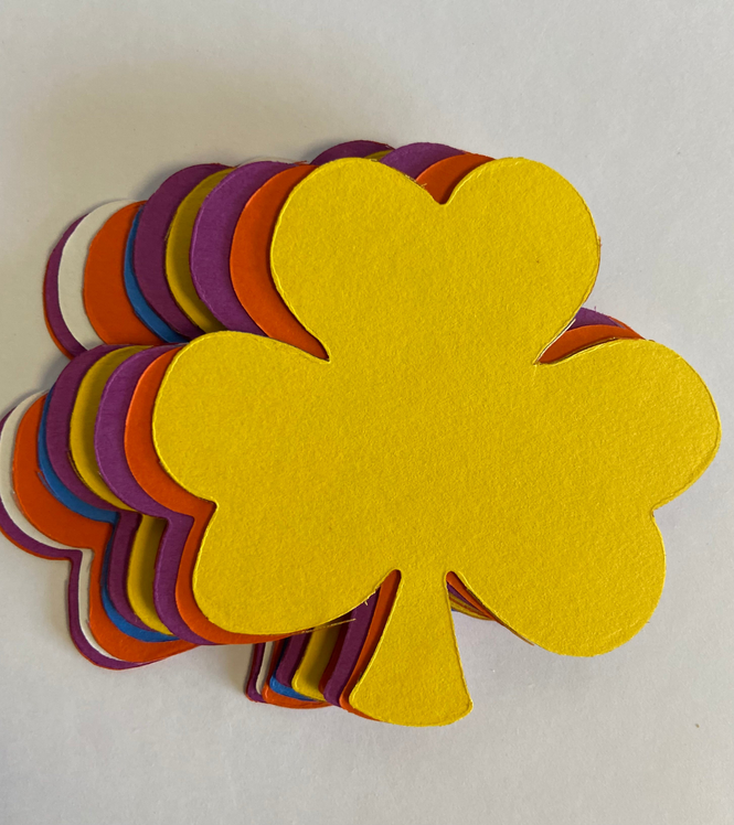 Assorted shamrock cut-outs stacked in yellow, orange, purple, and red tones