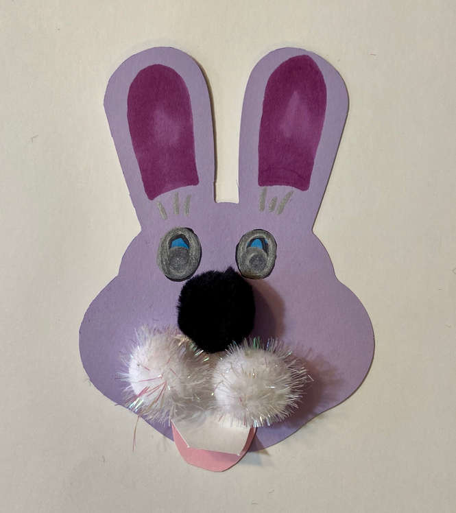 Lavender bunny cut-out with googly eyes, black nose, and fluffy white pom-poms