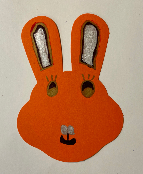 Orange bunny cut-out with tan inner ears, gray eyes, and small black smile