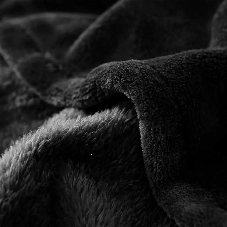 Close-up of black plush flannel blanket showing thick fuzzy pile