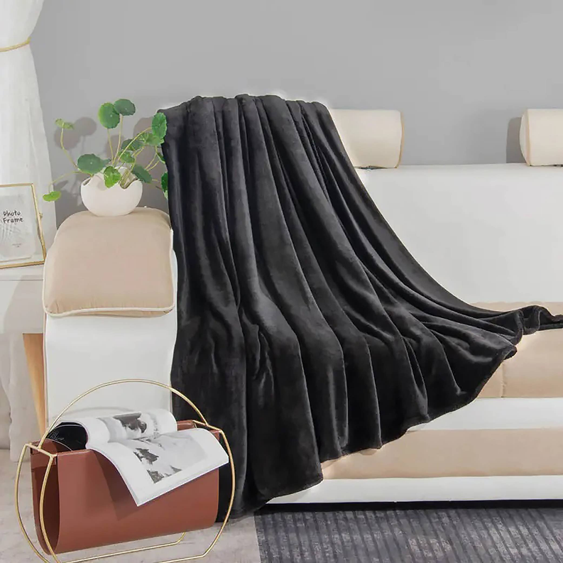 Black plush flannel throw blanket spread across bed, king size