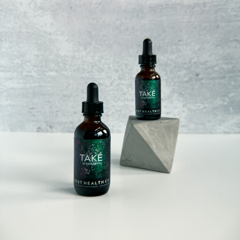 Two amber dropper bottles with black caps and TAKE labels, plus folded gray box.