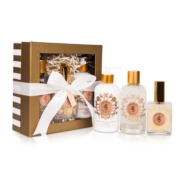 Open gift set box with white ribbon, with four bath bottles with gold accents