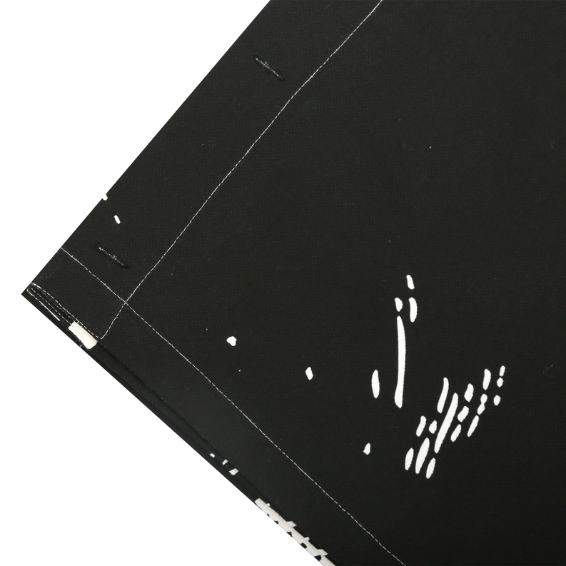 Black shower curtain fabric corner with stitched hem and face pattern