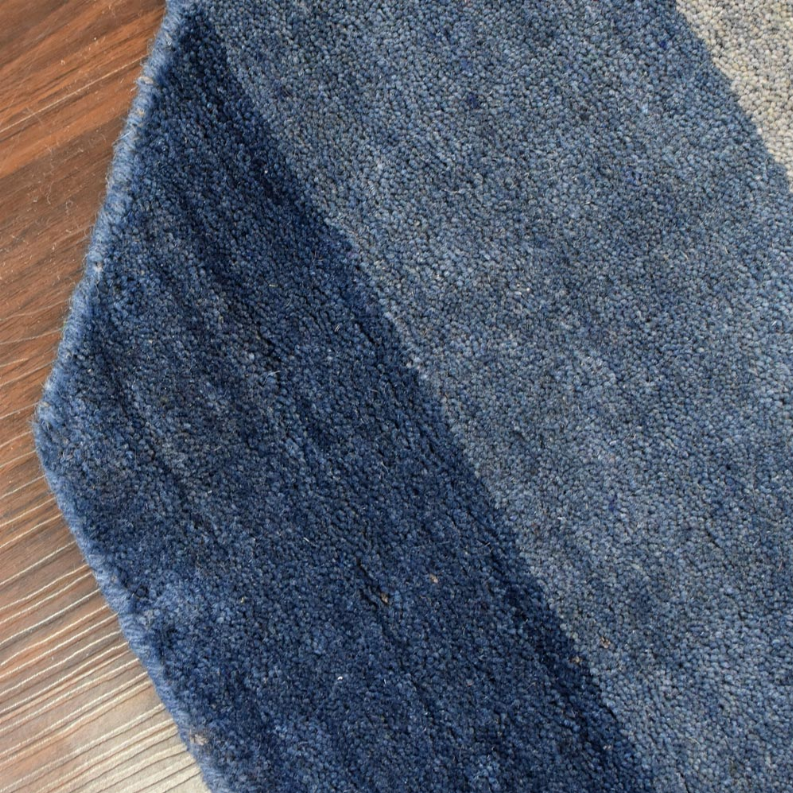 Blue and gray striped octagon wool rug close-up, showing dense short loop pile