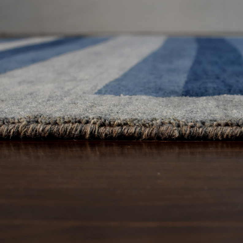 Octagon area rug edge view with fringe and light gray textured pile