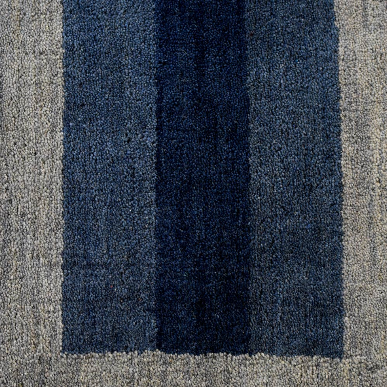 Octagon area rug close-up of navy center panel with light gray side stripes