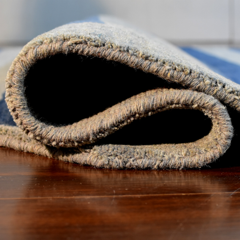Octagon area rug corner view with braided fringe and dark interior underside