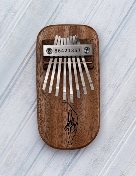 Wooden thumb piano with metal tines and engraved horse on the soundboard