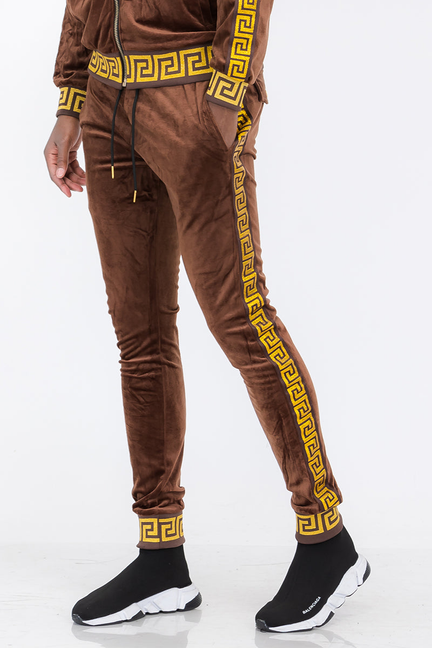 Brown velour track pants with gold Greek-key side stripe and elastic ankle cuffs