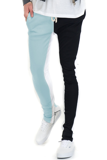 Split-tone track pants with light blue left panel and black right panel, zip pockets