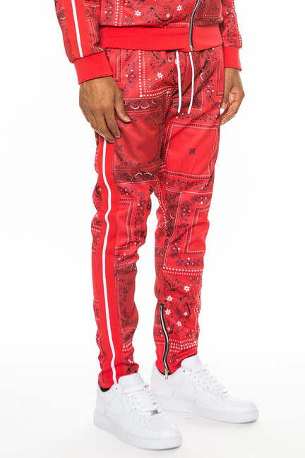 Red paisley all-over print track pants with drawstring waist and tapered legs