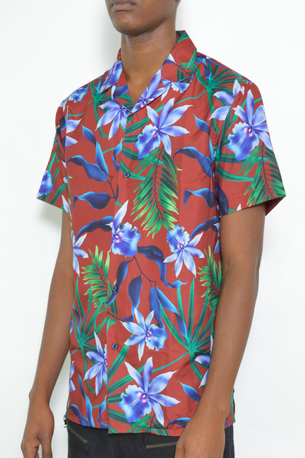 Short sleeve button-up shirt with tropical floral print, blue flowers and green leaves on red