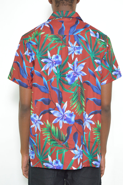 Back view short sleeve button-up shirt with tropical floral print, red base, green leaves, blue flowers