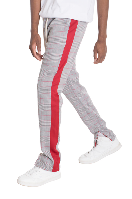 Plaid track pants with bold red side stripe and white sneakers