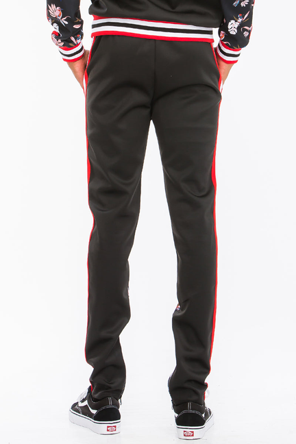 Black floral print track pants with red side stripe and ribbed striped waistband