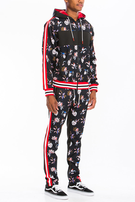 Black floral print track set with hooded jacket and red-striped pants, side view