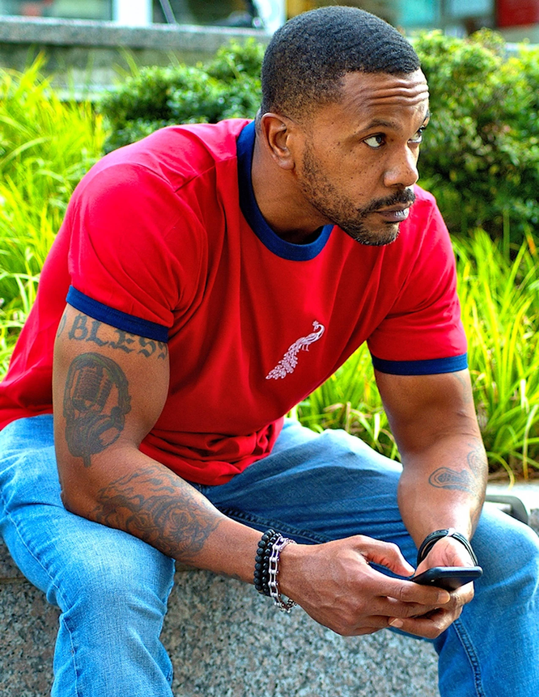 Red short-sleeve ringer tee with blue neckline trim and small embroidered chest graphic