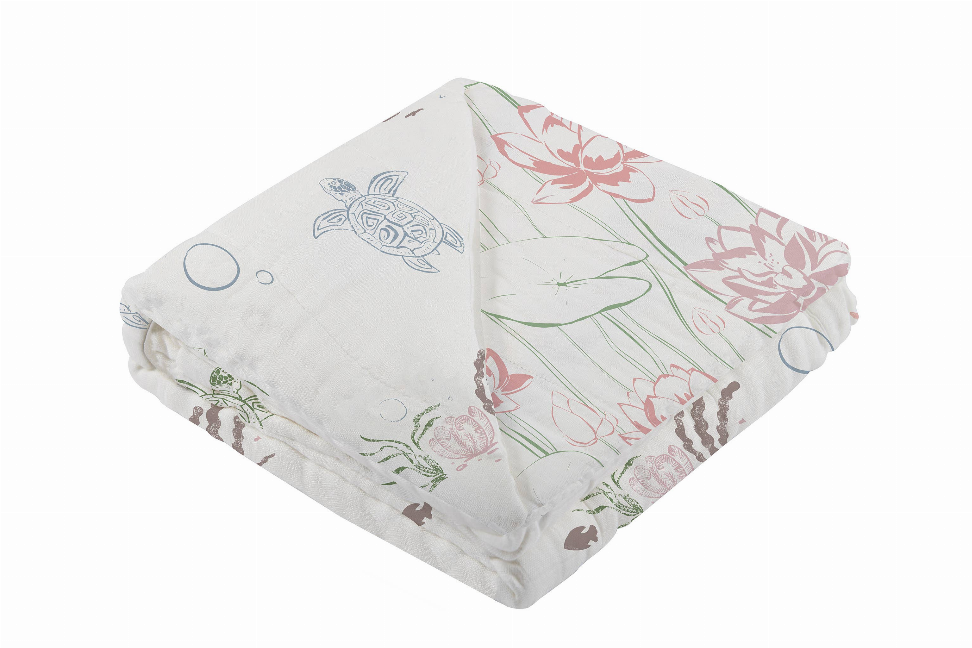 Folded bamboo blanket with light gray fabric and pink flowers, turtle, and leaf motifs