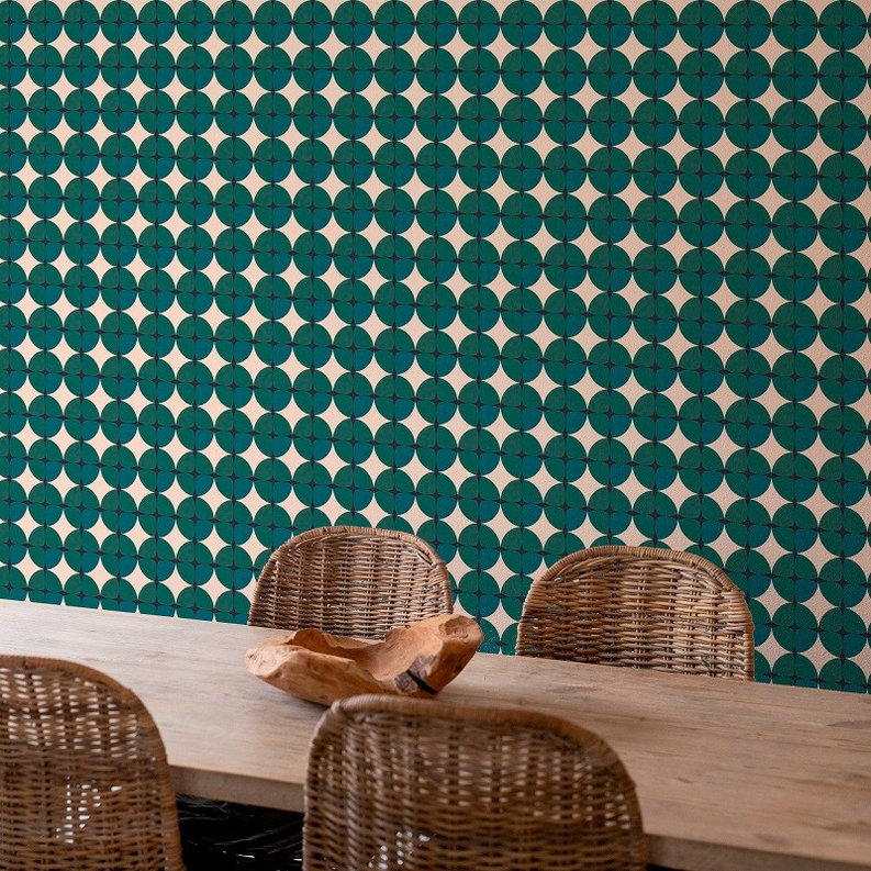 Peel-and-stick wallpaper on wall with repeating teal and dark green circular star pattern.