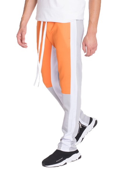 Orange and white color-block track pants with grey side panels and tapered leg