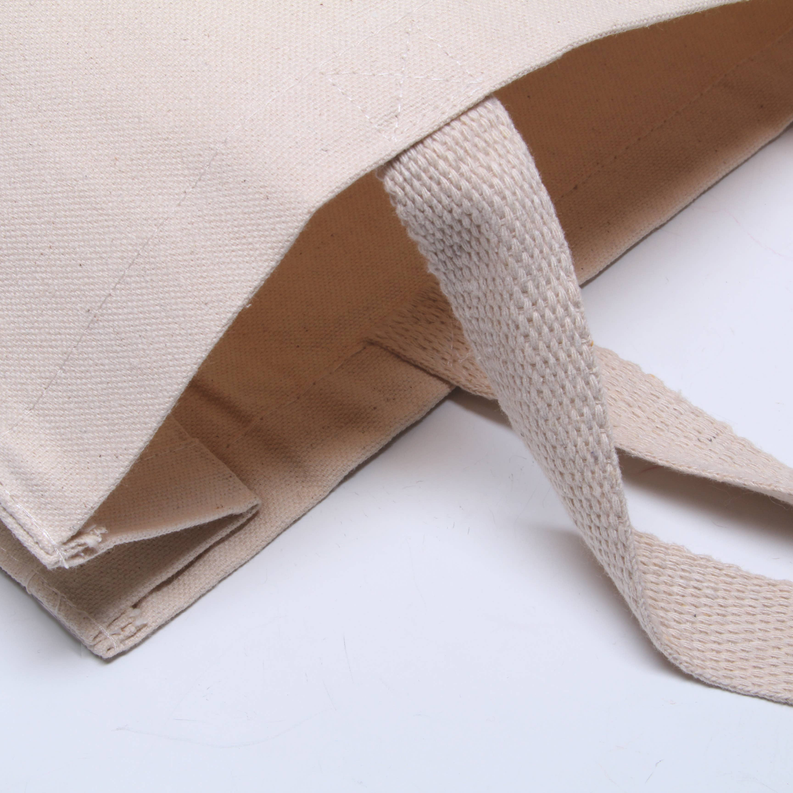 Canvas tote bag corner detail with reinforced seam and fabric strap