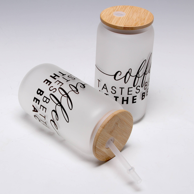 White mason jar tumbler with bamboo lid, drink straw, and printed coffee text