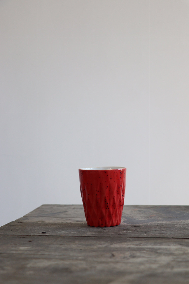 Handmade ceramic coffee cup with red speckled finish