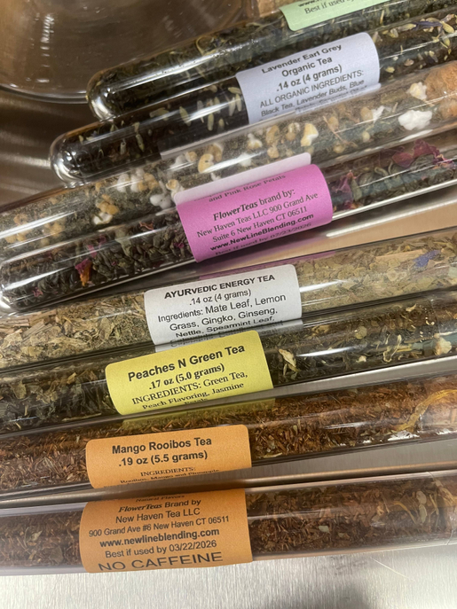 Close-up of clear tea test tubes with ingredient labels and tea mix
