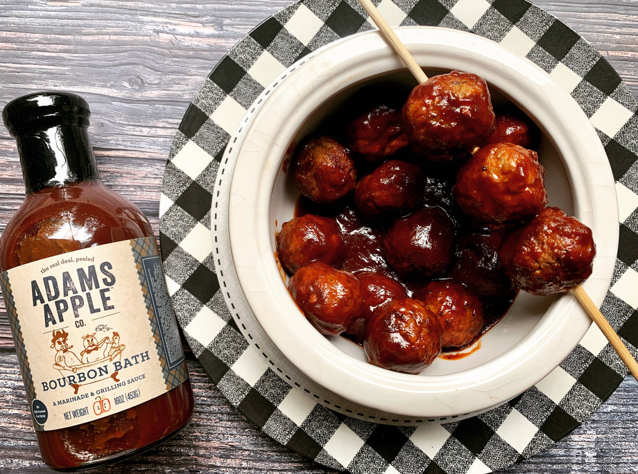 Bourbon bath sauce bottle and plate of glazed meatballs on check cloth