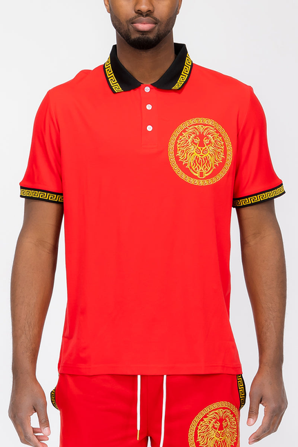 Red polo shirt with lion head logo, button placket, patterned gold collar and sleeve trim