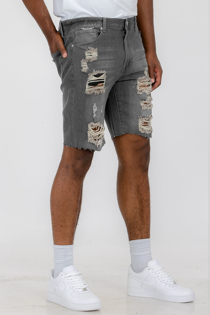 Grey washed distressed denim shorts with ripped knee and frayed patches