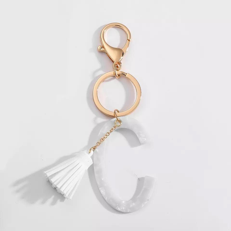 White tasseled initial key chain with gold ring and letter C charm