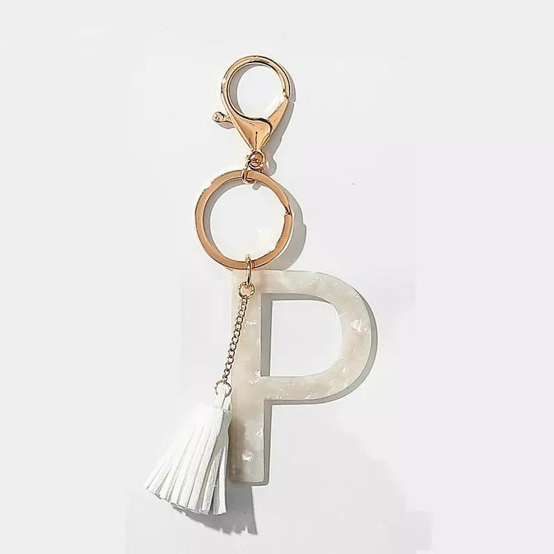 Tasseled initial key chain with letter P charm and white tassel on gold ring