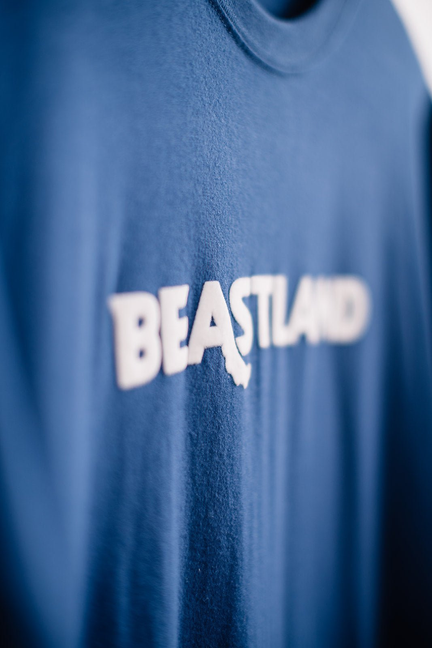 Blue crew-neck tee with large white BEASTLAND logo across the chest