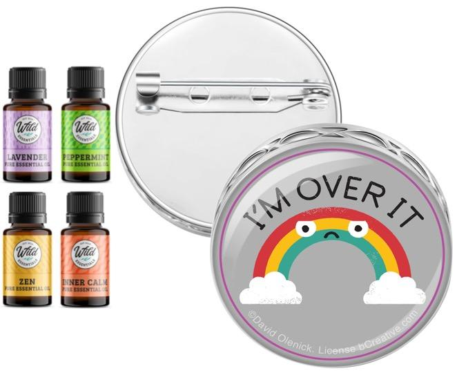 Pin brooch diffuser with chrome backing and 'I'M Over It' badge; includes 4 oil bottles.