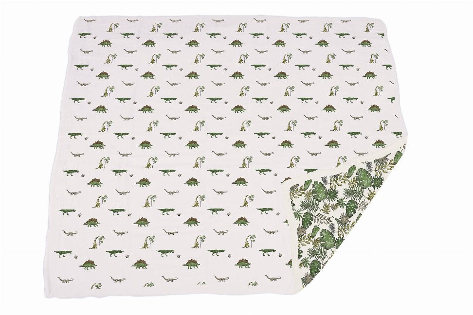 Cotton blanket with small green dinosaur print and tropical leaf corner panel