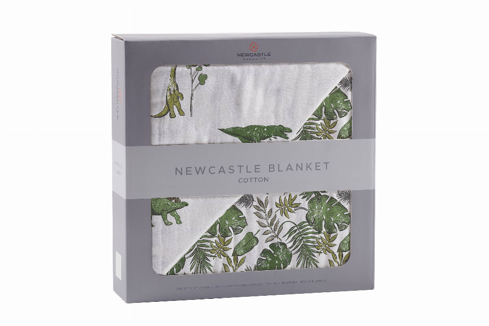Cotton blanket in gift box showing green dino and jungle leaf pattern