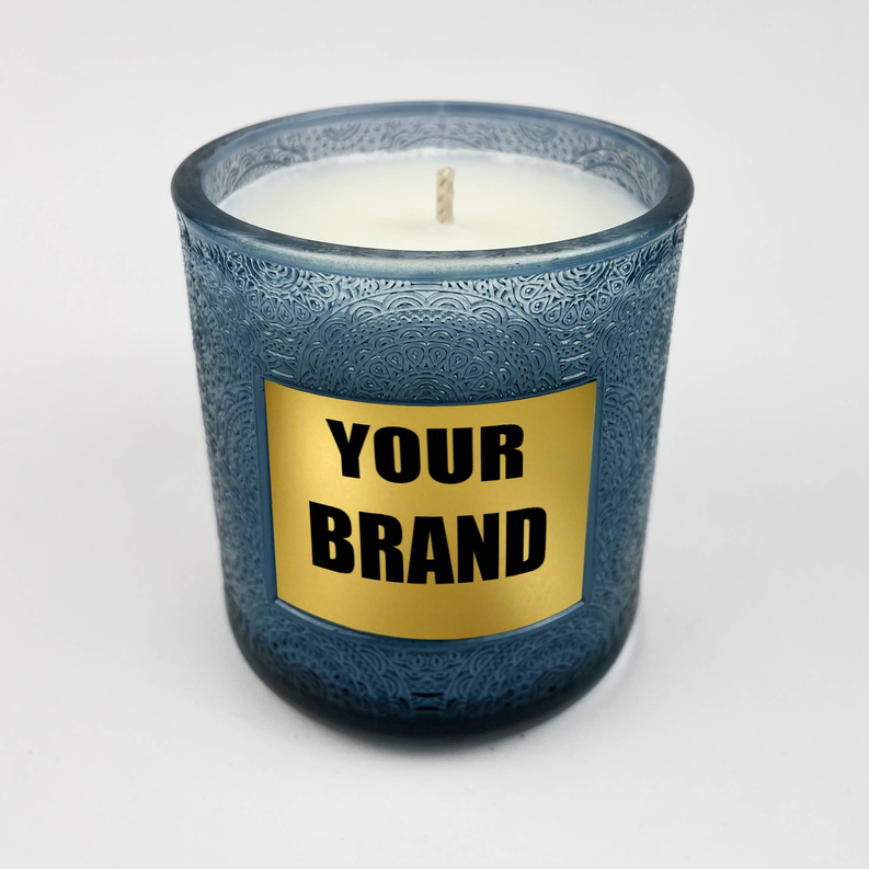 Blue glass candle with gold label reading 'YOUR BRAND' and visible wick