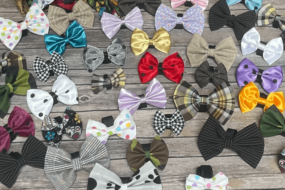 Assorted pet bow hair clips with polka-dot, plaid, and solid colors in teal, red, purple