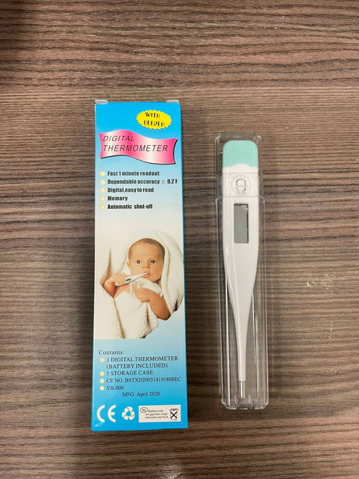 Digital oral thermometer in blister packaging with instruction box and storage case